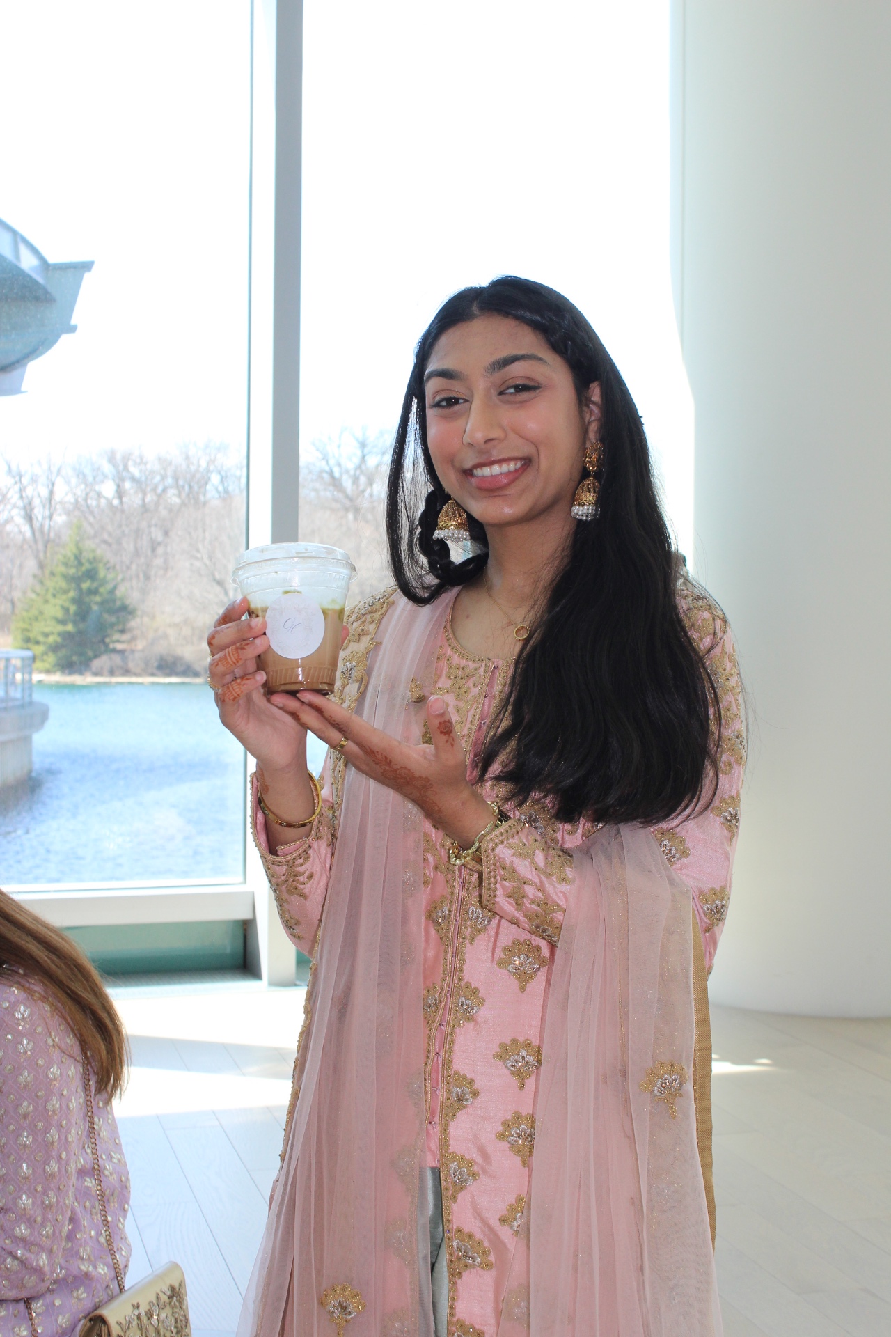 Wedding guest holding a Citrus & Olive signature iced latte