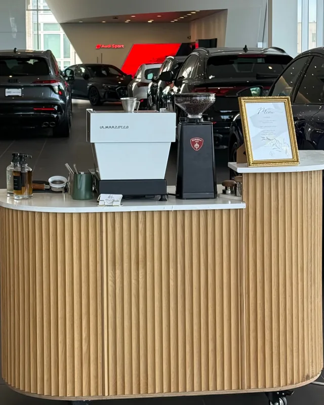 Citrus & Olive Flutes cart in fluted oak with a white top, set up with a La Marzocco espresso machine and Eureka grinder at an Audi showroom activation